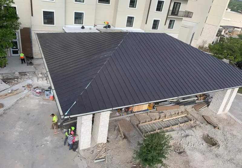 Metal roofing installation team working on a commercial building in Whitman